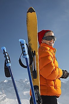 Woman smiling by ski and ski poles