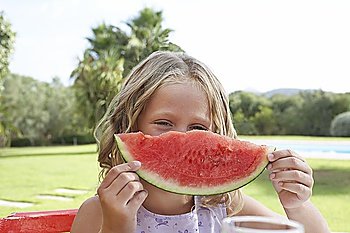 Portrait of girl (5-6) holding slice of watermelon