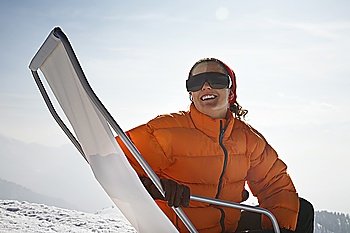 Woman sitting in lawn chair in snow