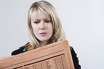 Businesswoman Reading Stock Listings in Newspaper