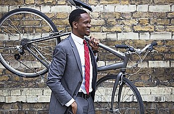 Portrait of African American businessman carrying Bicycle
