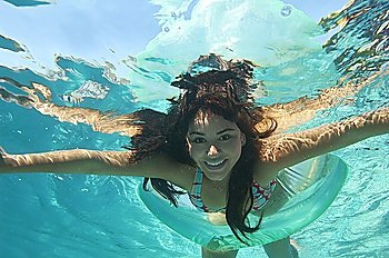 Young woman swimming in pool, underwater view
