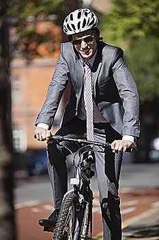 Portrait of happy young businessman riding bicycle