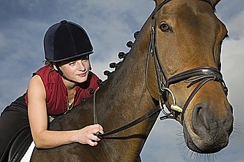 Female horseback holding bridle