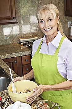 Portrait of a happy senior woman preparing food in kitchen
