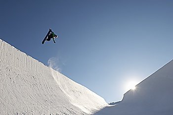 Silhouette of teenage snowboarder on  halfpipe