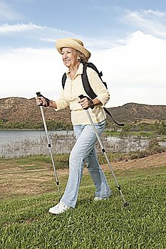 Senior woman orienteering with walking poles