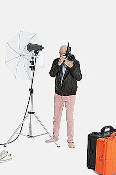 Senior photographer taking a photograph in studio