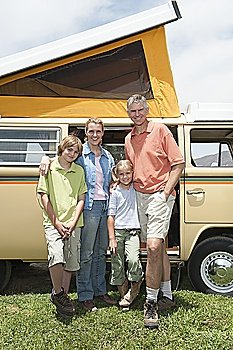 Family of four stand at campervan