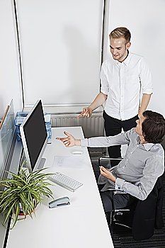 Businessmen pointing at computer screen in office