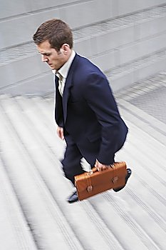 Business man carrying briefcase, ascending steps, elevated view