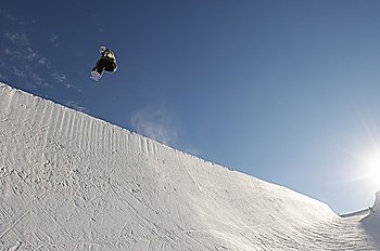 Silhouette of teenage snowboarder on halfpipe