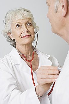 Senior medical practitioner examines man with stethoscope
