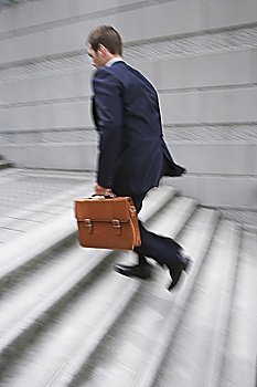 Business man carrying briefcase, ascending steps