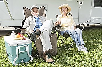Senior couple sit outside RV home