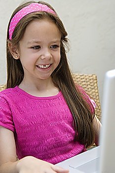 Smiling Little Girl Using a Laptop