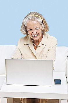 Cheerful senior woman using laptop for video calling