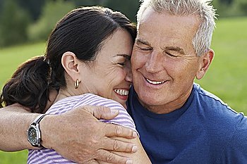 Sernior man and middle-aged woman embracing, laughing