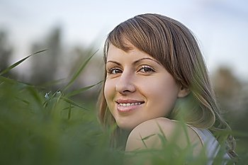 Young woman lies in a field of grass