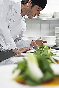 Male chef preparing salad in kitchen