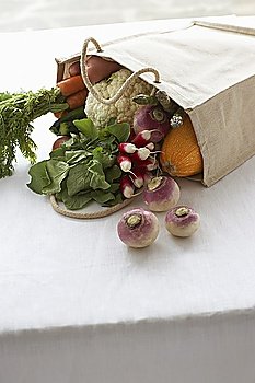 Bag full of fresh vegetables on table, close-up