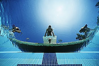Underwater view of swimmers on diving boards