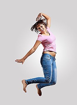 pretty modern slim hip-hop style woman jumping dancing on a grey background