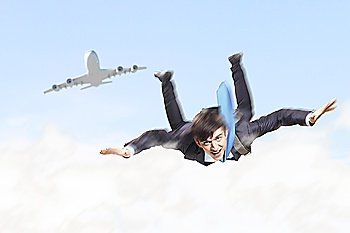 Conceptual image of young businessman flying with parachute on back