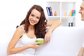Portrait of lovely young woman having cup of tea at home