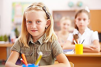 Little girl sitting and studying at school class