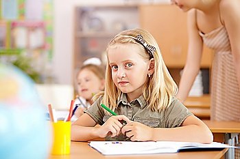 Little girl sitting and studying at school class