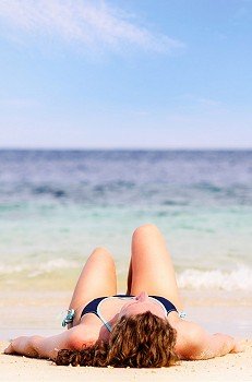 young woman is lying on beach