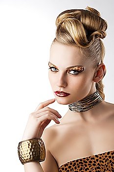 fashion beauty portarit of blond young cute girl with creative hair style and leopard make up, she is turned of three quarters looks in to the lens and has the right hand near her mouth