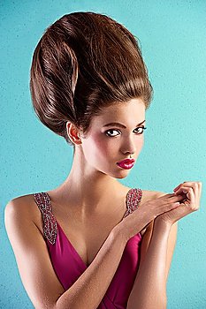 fashion shot of a beautiful brunette with a couture hair style wearing a pink evening dress