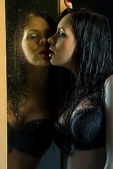 sexy and beautiful brinette in black lingerie playing with herself through a dropped mirror with wet hair