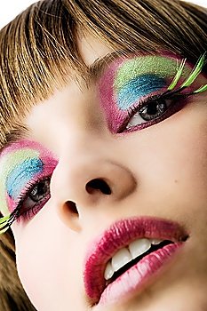 face close up of young girl with color creative make up looking in camera