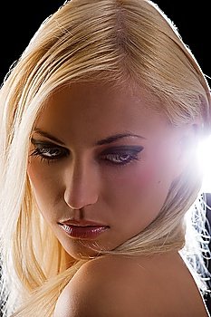 sensual portrait of beautiful blond woman with a fashion make up on black background and back light