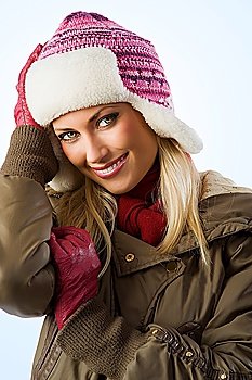 beautiful blond girl wearing a winter breakwind jacket scarf gloves and pink hat