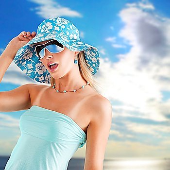 summer girl in light blue with hat and sunglasses in hot expression