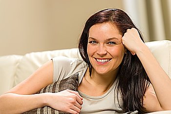 Young smiling woman relaxing at home lying on the couch