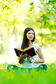 Woman reading book in park outdoors
