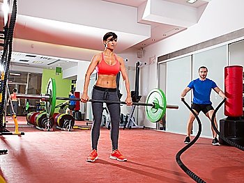 Crossfit fitness gym weight lifting bar woman and man battling ropes workout