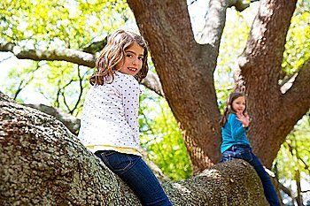 kid children girls playing riding a tree branch up high