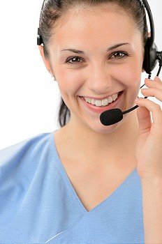 Smiling female customer support phone operator looking at camera