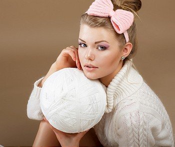 Pure Beauty. Woman in White Fluffy Knitted Pullover with Hank of Thread