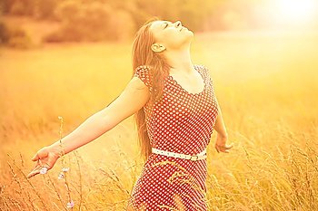 Summer Fun. Young happy woman enjoying sunlight on the wheat meadow