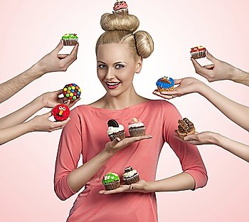 pretty blonde girl with colored make-up and funny hair-style taking cupcakes. Some hands tendering other colorful cupcakes