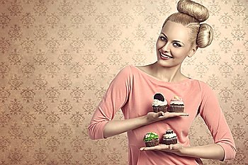 beautiful blonde girl with creative hair-style and colourful make-up taking four  variety of sweets cupcakes  in the hands