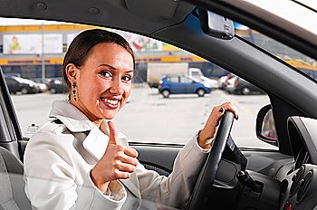 happy woman is showing a thumb from a car