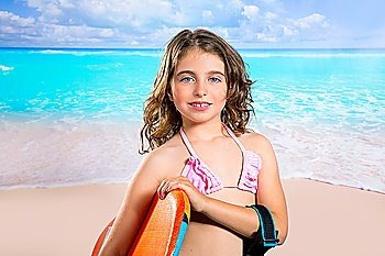 Children fashion surfer girl in tropical turquoise beach vacation smiling